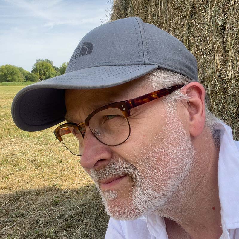 avatar of tim's face in baseball-cap and glasses
